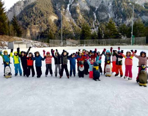 Eine Gruppe von Kindern, die auf dem Eislaufplatz stehen